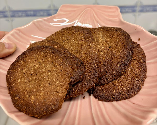 Golden-brown keto Chocolate almond cookies served on a pink ceramic plate